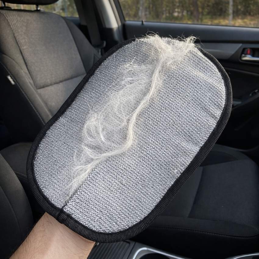Removing a clump of white dog hair from a black car seat using the PurePath glove